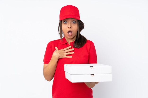 孤立した白い壁の上の若いピザの配達の女性が驚いて、右を見ながらショックを受けた