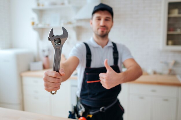 Young plumber hold wrench in hand