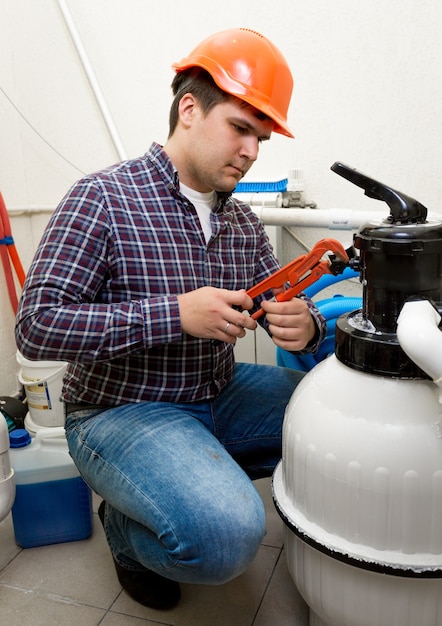 Young plumber installing manometer on high pressure barrel