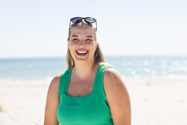 Young plus size Caucasian woman smiles brightly at the beach