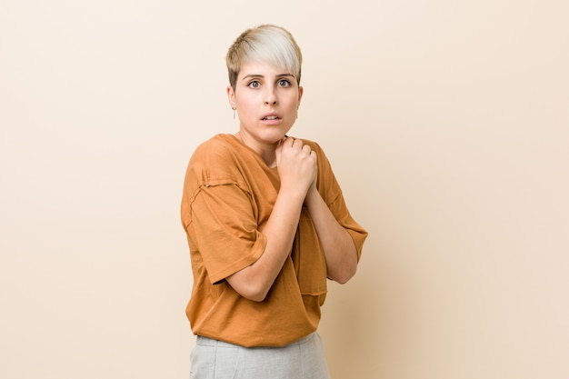 Young plus size woman with short hair scared and afraid.