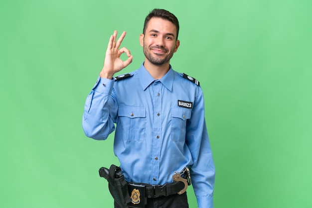 Photo young police caucasian man over isolated background showing ok sign with fingers