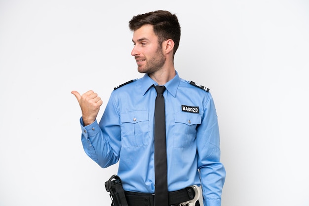 Foto giovane uomo caucasico della polizia isolato su sfondo bianco che indica il lato per presentare un prodotto