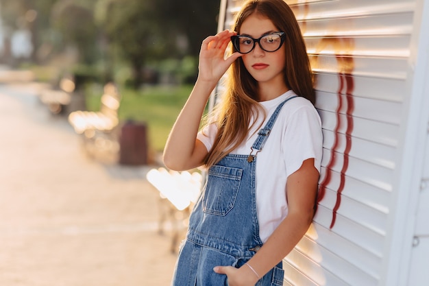 Young positive attractive pretty girl in stylish glasses at morning sunshine