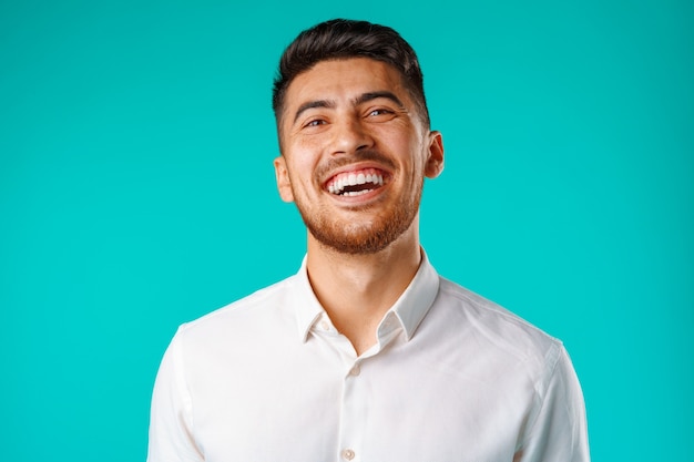 Young positive european man standing in blank white shirt laughing close up