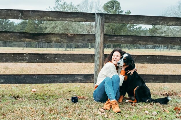 Foto giovane donna positiva che cammina con il cane scena rurale proprietario di cane allegro