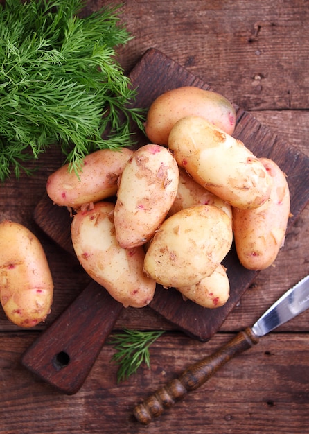 Young potatoes in a wooden plate on a wooden background