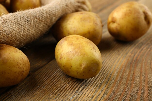 Young potatoes on wooden table close up