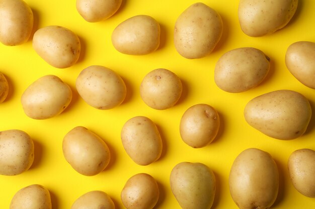 Young potatoes on yellow surface