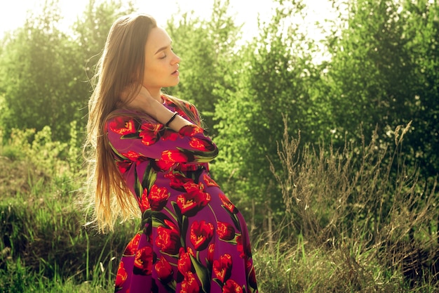 Young Pregnant girl in dress in nature