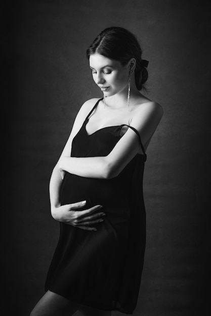 Photo a young pregnant girl in a dress.