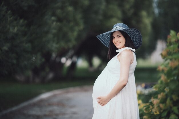 公園で夏の日に妊娠中の若い女の子お母さんはbaby39sの誕生を待っています