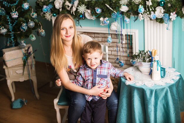 Young pregnant mother and child celebrating Christmas at home