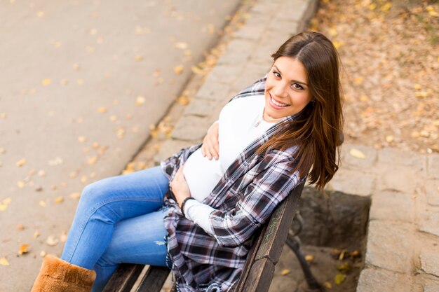 Young pregnant woman in the autumn park