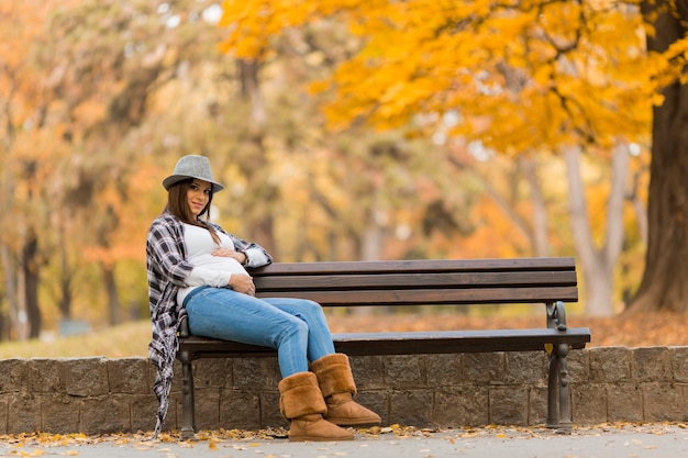 Foto giovane donna incinta nel parco autunnale