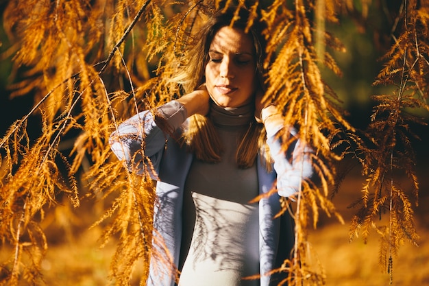 Young pregnant woman in the autumn park