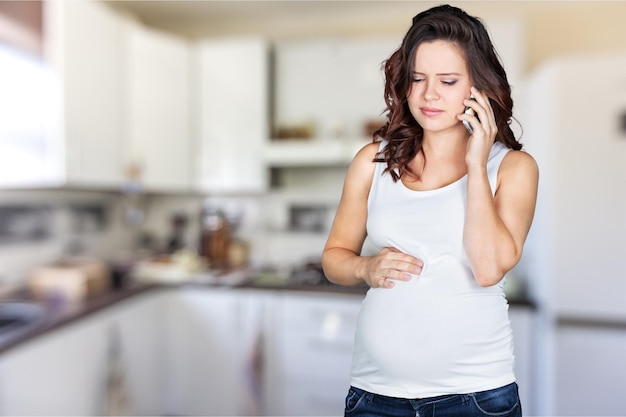 Young pregnant woman on blurred kitchen interior