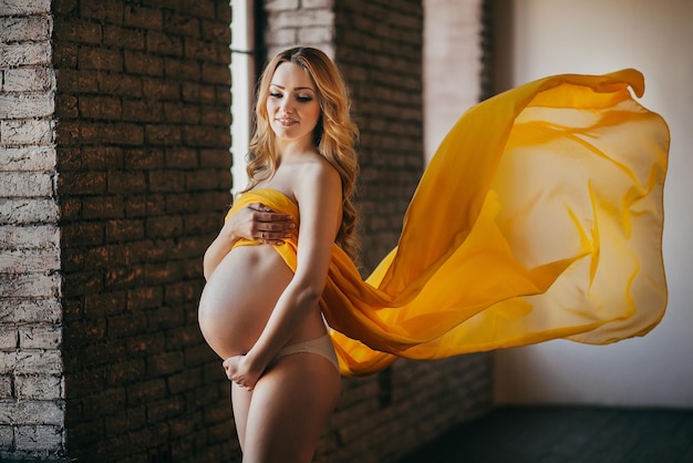 Young pregnant woman in colorful fabric