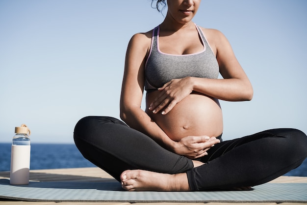 Young pregnant woman doing yoga outdoor