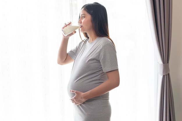 Young pregnant woman drinking milk at home healthcare and pregnancy care