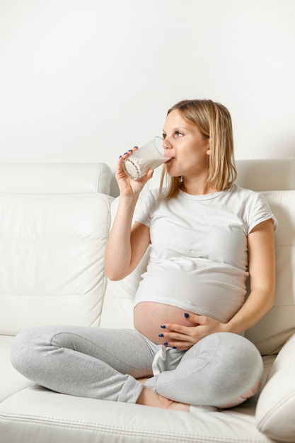 Foto latte alimentare della giovane donna incinta