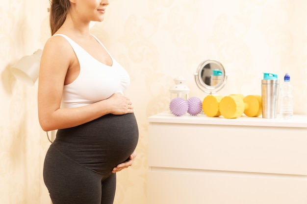 Young pregnant woman during her fitness workout at home