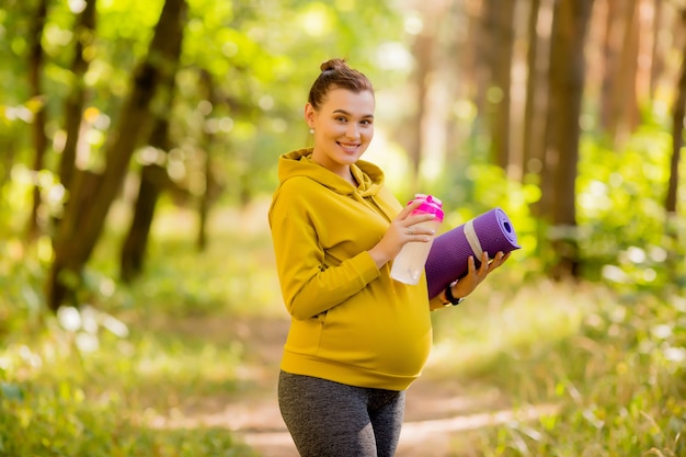 若い妊娠中の女性は屋外スポーツに従事しています。