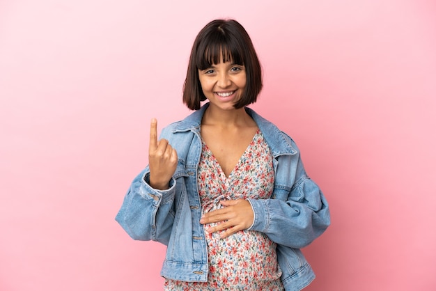 Young pregnant woman over isolated pink background doing coming gesture