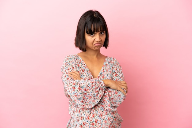 Young pregnant woman over isolated pink background with unhappy expression