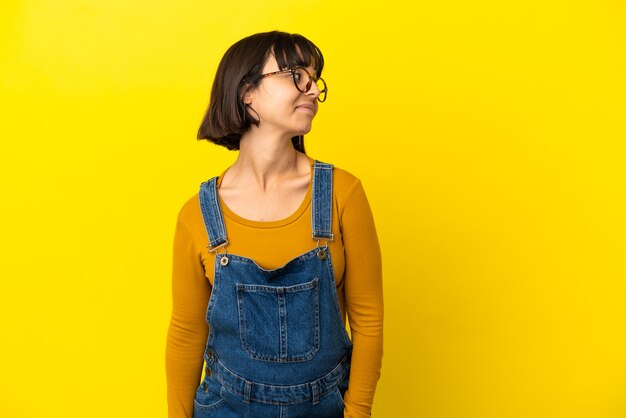 Young pregnant woman over isolated yellow background . Portrait