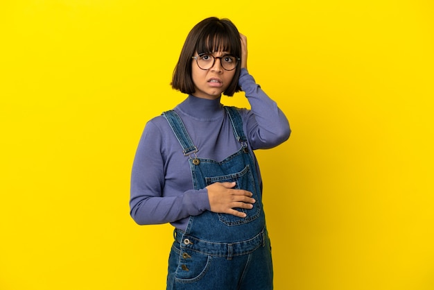 Photo young pregnant woman over isolated yellow background with an expression of frustration and not understanding