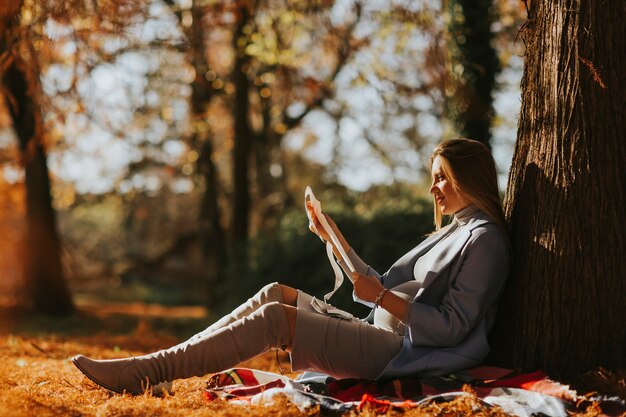 Young pregnant woman looking fetus ultrasound images in the park