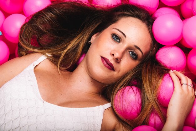 Young pregnant woman playing in a pink ball pool