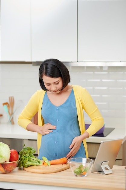 사진 집 부엌에서 야채를 많이 가진 건강 식품을 준비하는 젊은 임산부