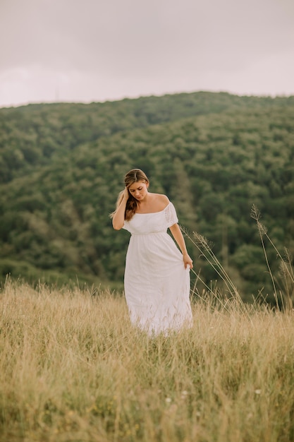 Young pregnant woman relaxing outside in nature