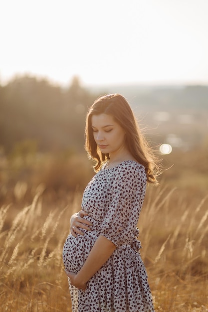 Young pregnant woman relaxing in park outdoors