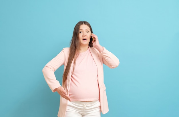 Young pregnant woman talking on the phone