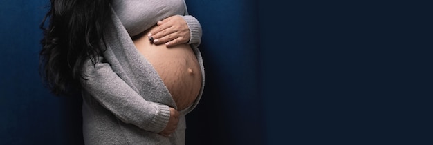 若い妊娠中の女性が青い背景、赤ちゃん待機コンセプト