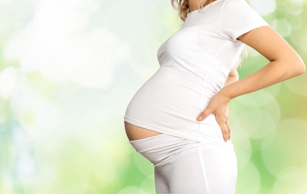 Young pregnant woman in white clothes