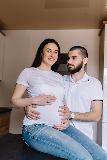 Young pregnant woman with her husband at home