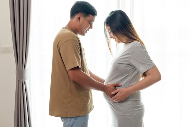 사진 남편이 집에서 아기를 안고 기대하는 젊은 임산부