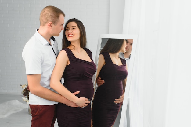 Young pregnant woman with husband posing