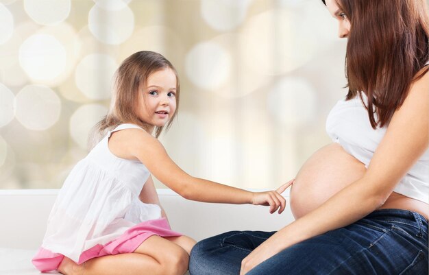 Young pregnant woman with little girl