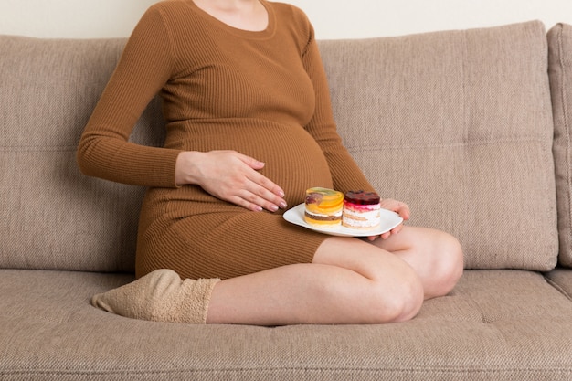 Young pregnant woman with sweets