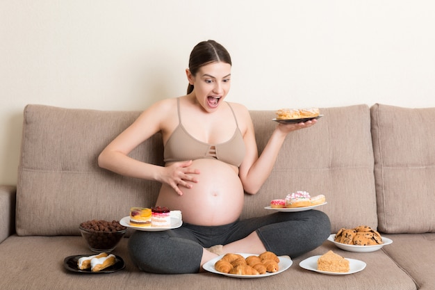 Young pregnant woman with sweets