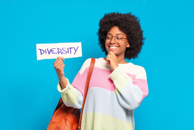 Young pretty afro woman holding diversity banner