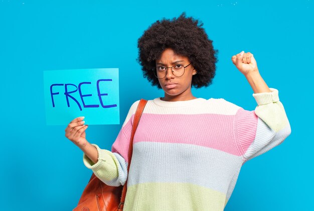 Young pretty afro woman holding free concept banner