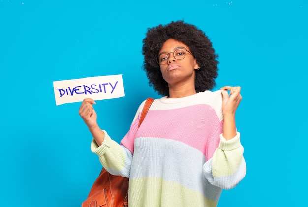 Young pretty afro woman holding paper with diversity concept banner