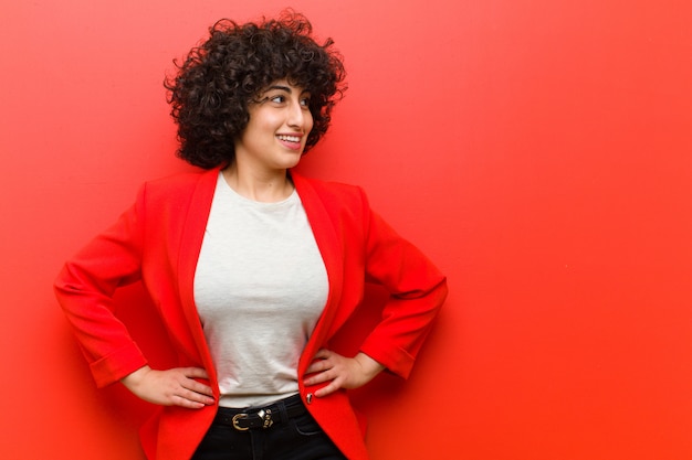 Giovane donna afro graziosa che sembra felice, allegra e sicura