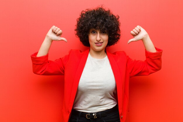 Giovane donna afro graziosa che sembra triste deludente o arrabbiato mostrando i pollici giù in disaccordo sentirsi frustrato